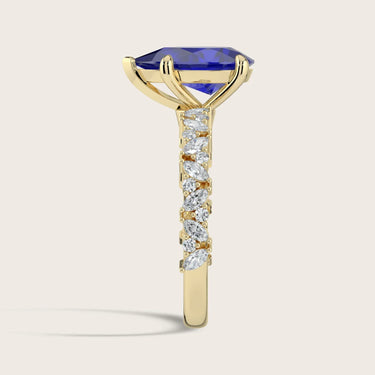 Lab-grown "pear" sapphire ring. 18k yellow gold band with diamond accents, side view.