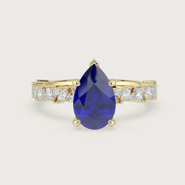 18k yellow gold engagement ring featuring a pear-shaped "lab-grown sapphire" and diamond band.