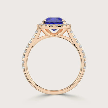 Rose gold ring with pear cut lab-grown sapphire, "halo" diamond setting, and diamond band.
