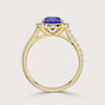 Close-up of a "lab-grown pear sapphire" ring with diamond halo and band in 18k yellow gold.