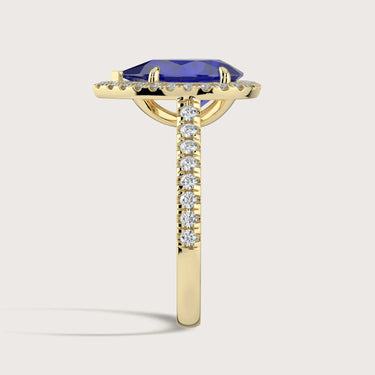 Lab-grown pear sapphire ring in "18kyg" with diamond halo and band, side view.