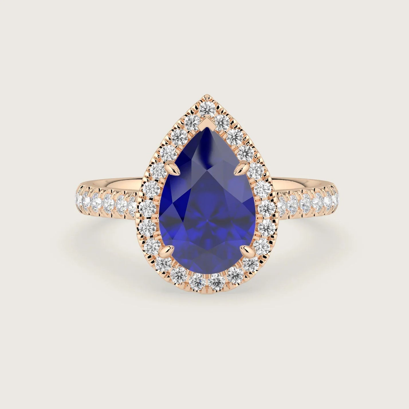Pear-shaped lab-grown sapphire engagement ring with diamond halo and band in 18k rose gold.