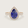 Pear-shaped lab-grown sapphire engagement ring with diamond halo and band in 18k rose gold.