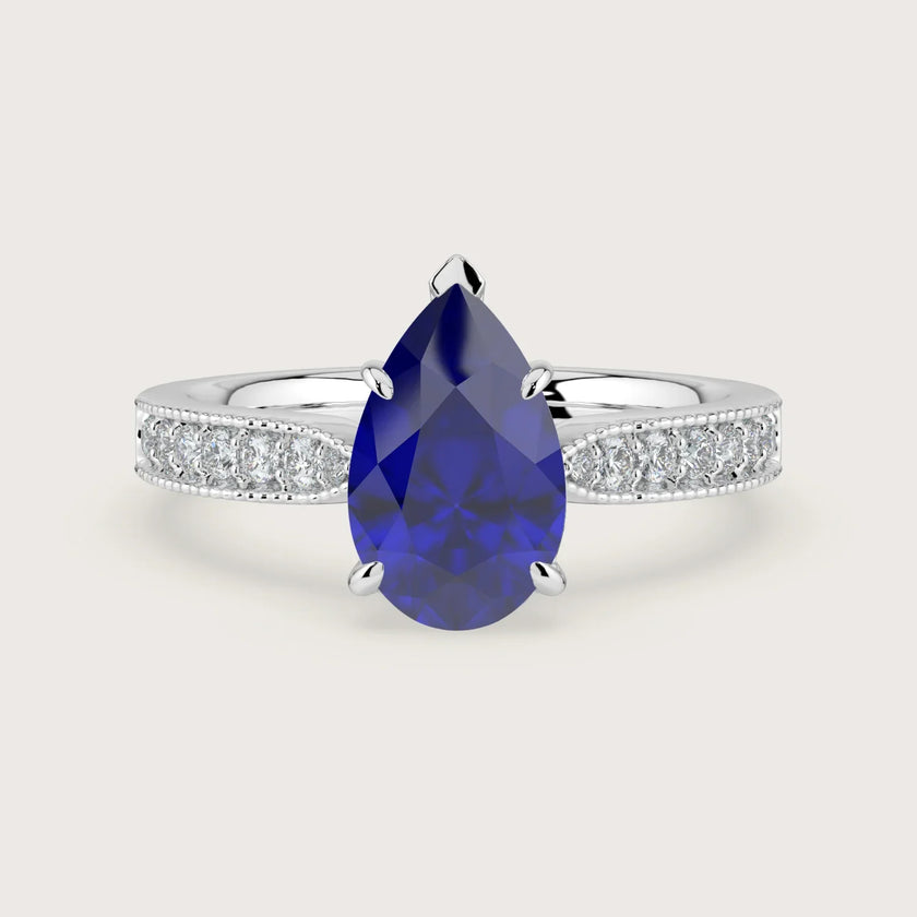 Pear-shaped lab-grown sapphire engagement ring with milgrain diamond band in 18k white gold.
