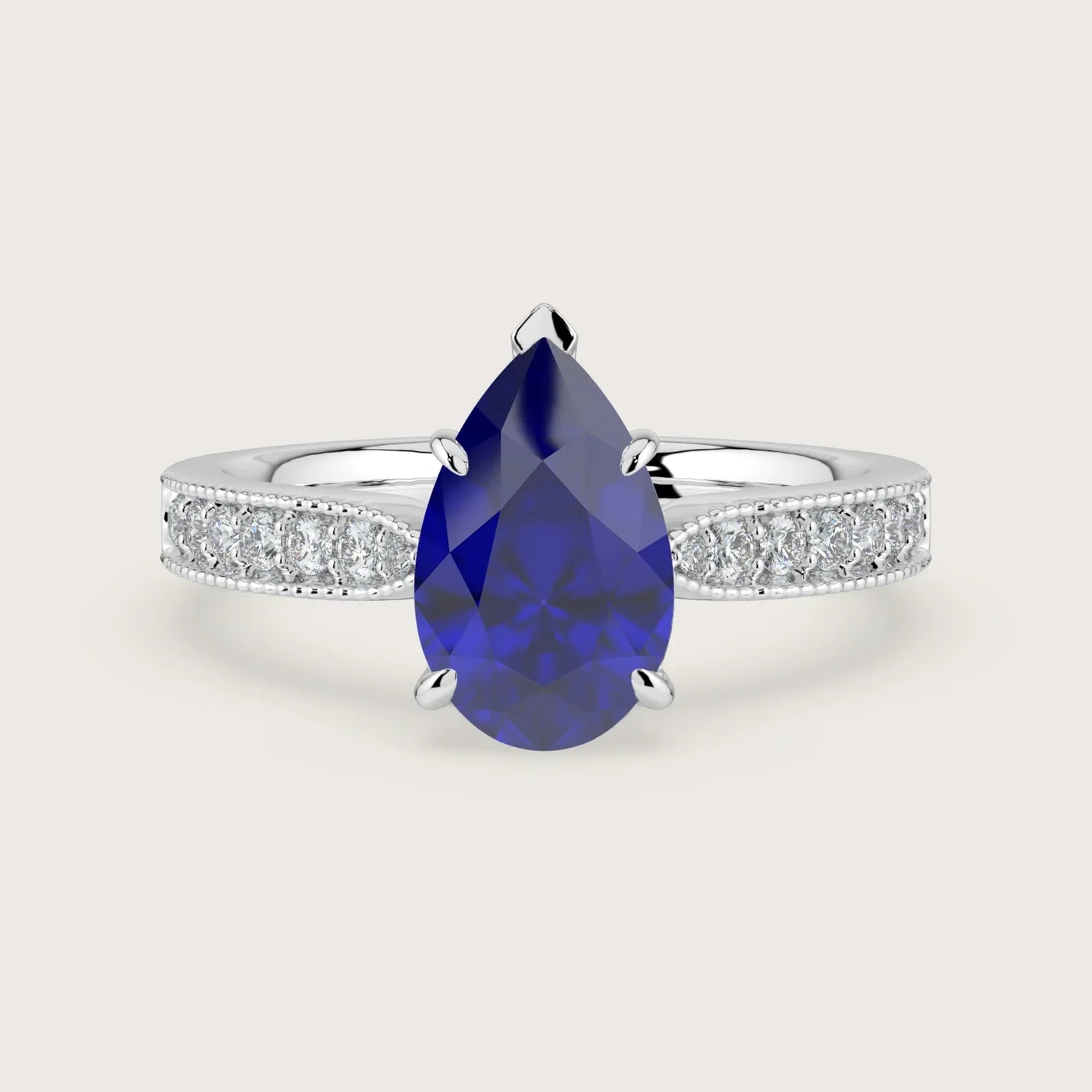 Pear-shaped lab-grown sapphire engagement ring with milgrain diamond band in 18k white gold.