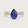 Lab-grown pear sapphire engagement ring. 18k two-tone band with milgrain detail and diamond accents.